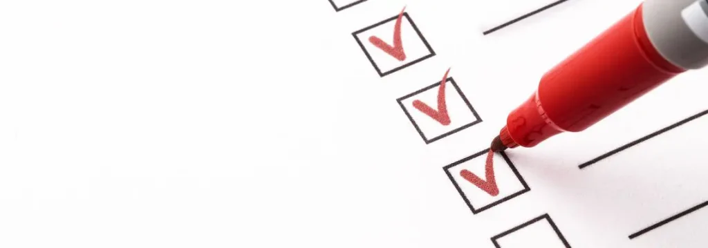 Red pen drawing checkmarks in boxes
