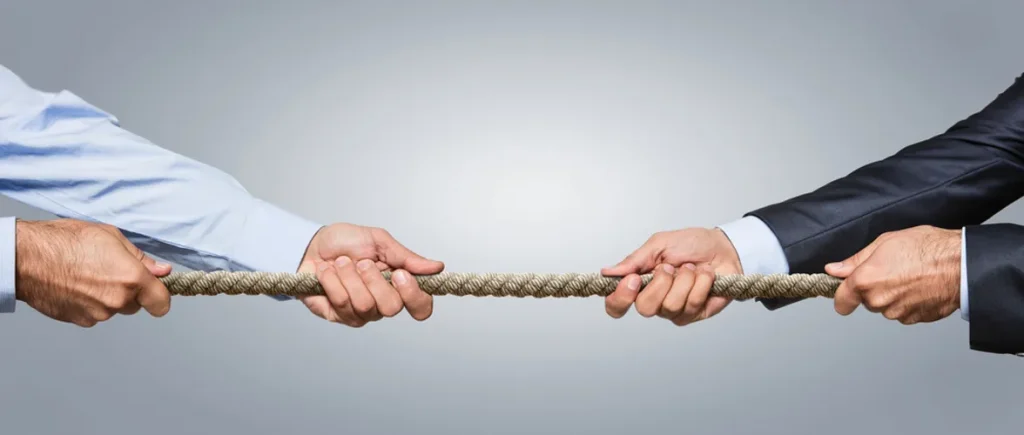 Two well dressed men pulling on a rope against each other